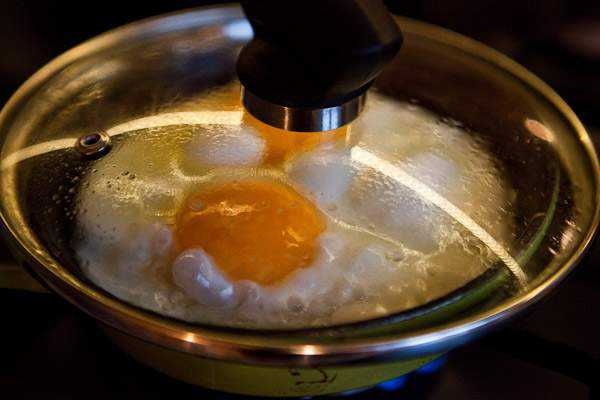 Яйцо на воде в сковороде. Сковорода накрытая крышкой. Яичница с закрытой крышкой. Омлет под крышкой. Разбивание яиц на сковороду.